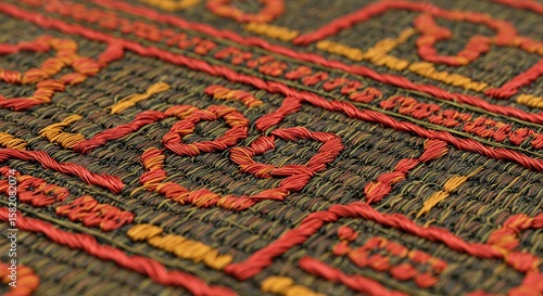 Rich textile texture displays intricate embroidery patterns in red and gold, showcasing detailed craftsmanship on a woven brown background for fashion and design elements.