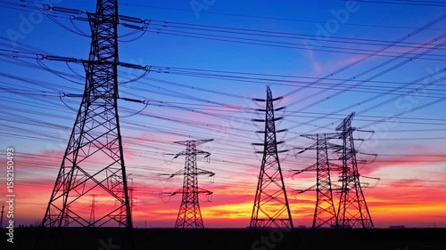 High voltage power tower and power lines with beautiful sky clouds at dusk