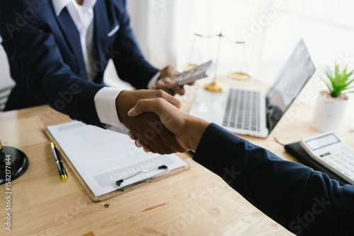 Close-up of lawyer giving legal advice showing professional handshake which is a symbol of fairness, agreement, trust and successful negotiation between lawyer and client in business or court.