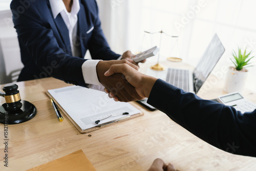 Close-up of lawyer giving legal advice showing professional handshake which is a symbol of fairness, agreement, trust and successful negotiation between lawyer and client in business or court.