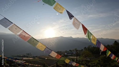 Prayer flags blowing by the wind in sacred place in rural Nepal. The prayer flags initiate peace and good tidings, their sacred mantras etched on the wind.