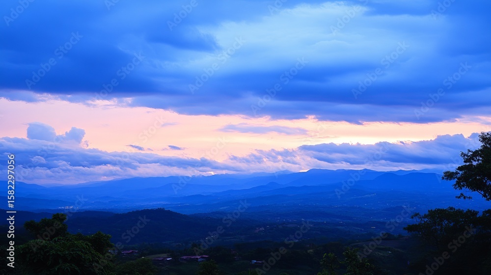 Obraz premium Serene twilight landscape showcasing a breathtaking panorama of layered mountains under a vibrant, colorful sky