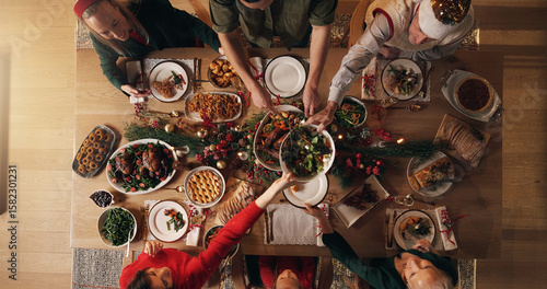 Fototapeta Festive, meal and people in home, reunion and celebration of Christmas with food at night or dinner