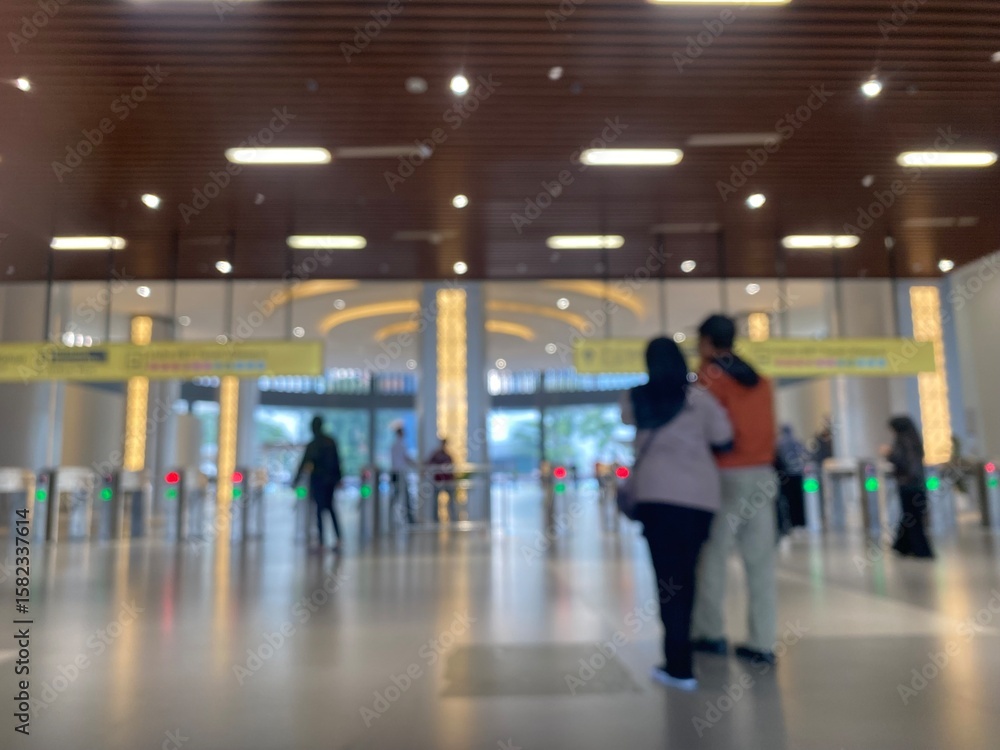 Fototapeta premium Jakarta, June 20, 2025. Background of the area inside the station with the ticket counter, the station entrance gate and the public in the background. Blurred