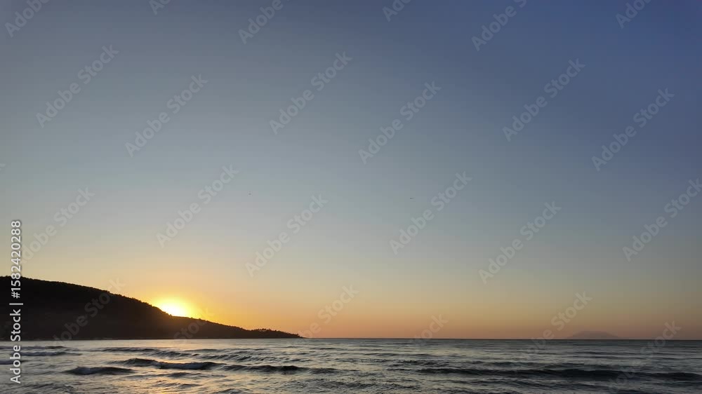 Sunrise on the coast with calm, rolling waves Sunrise on the coast with calm, rolling waves