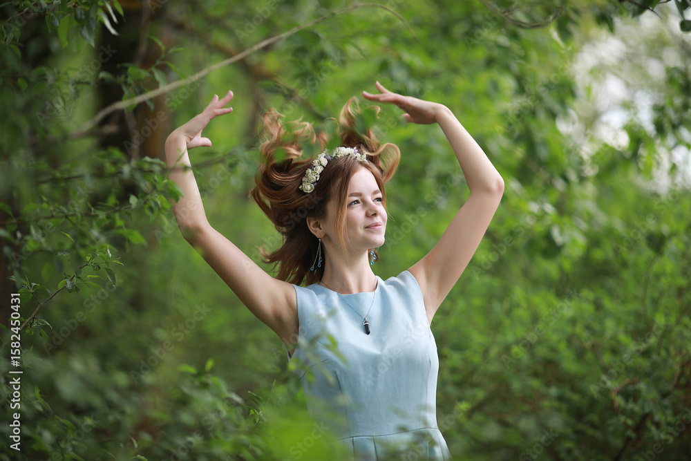 Fototapeta premium Girl in blue dress in green park