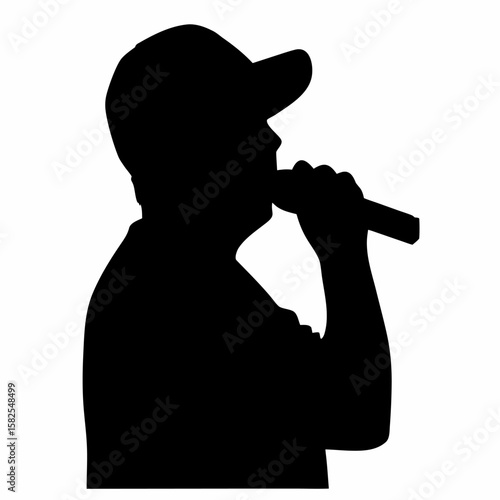 Silhouette of a male singer performing with a microphone wearing a baseball cap on stage