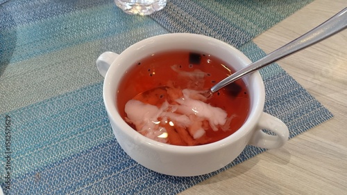 A refreshing iced drink made from young coconut, mixed with grass jelly and colorful jelly pieces. Served cold, it is a popular tropical beverage in Indonesia.