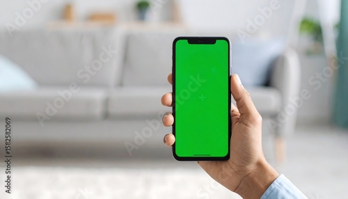 Wallpaper Mural Smartphone held in hand, green screen display.  Modern living room background Torontodigital.ca