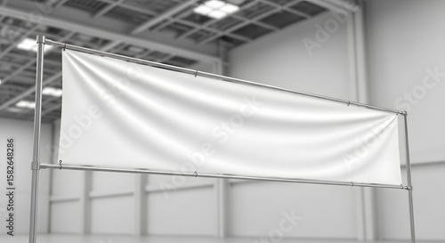 Blank white banner on a metal stand, perfect for advertisement or display in an empty warehouse or exhibition hall. A clean, realistic photo mockup.