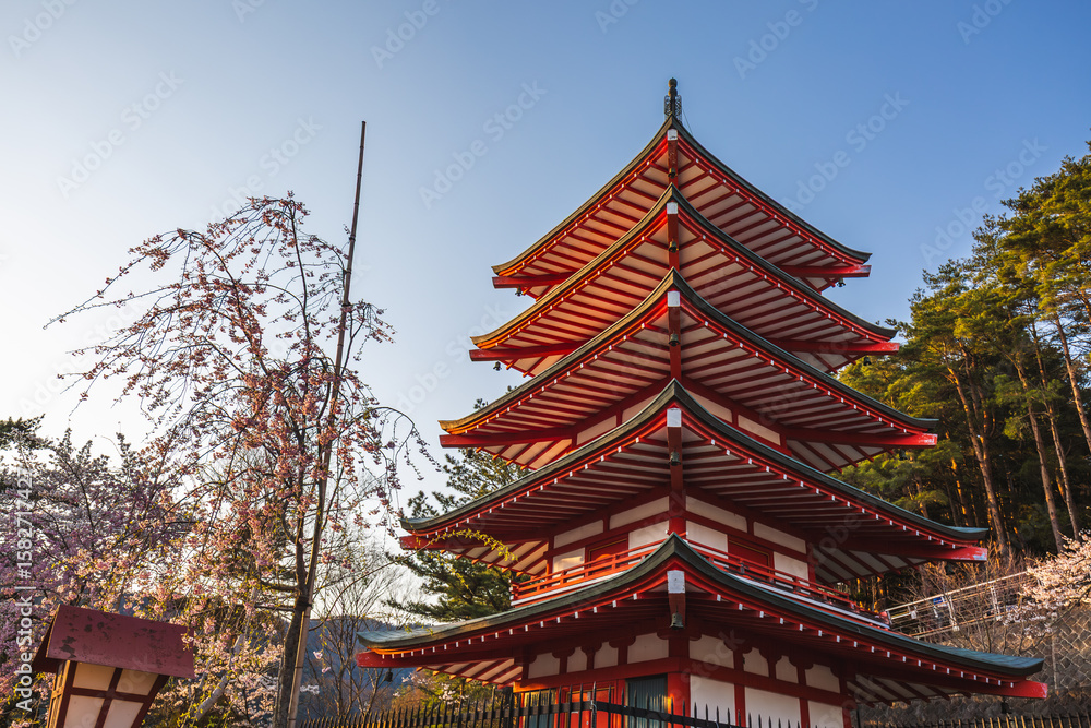 Red pagoda in Japan during cherry blossom season. The vibrant structure contrasts beautifully with the delicate pink blossoms. A serene and picturesque scene. Red pagoda in Japan during cherry blossom season. The vibrant structure contrasts beautifully with the delicate pink blossoms. A serene and picturesque scene.