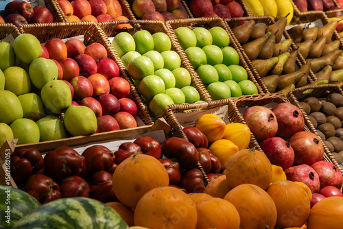 Colorful fresh fruits display in wicker baskets at farmers market produce stand