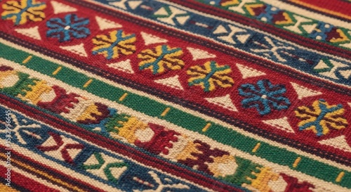 Close-up of a colorful, patterned woven textile with geometric shapes, floral motifs, and vibrant stripes in red, green, blue, yellow, and white.