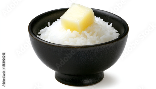 A small black bowl filled with cooked white rice, topped with a cube of yellow butter.