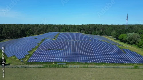 Wallpaper Mural Photovoltaic panels providing clean energy in a solar farm on hill near a forest in Germany. Smooth aerial view flight overflight flyover drone Torontodigital.ca