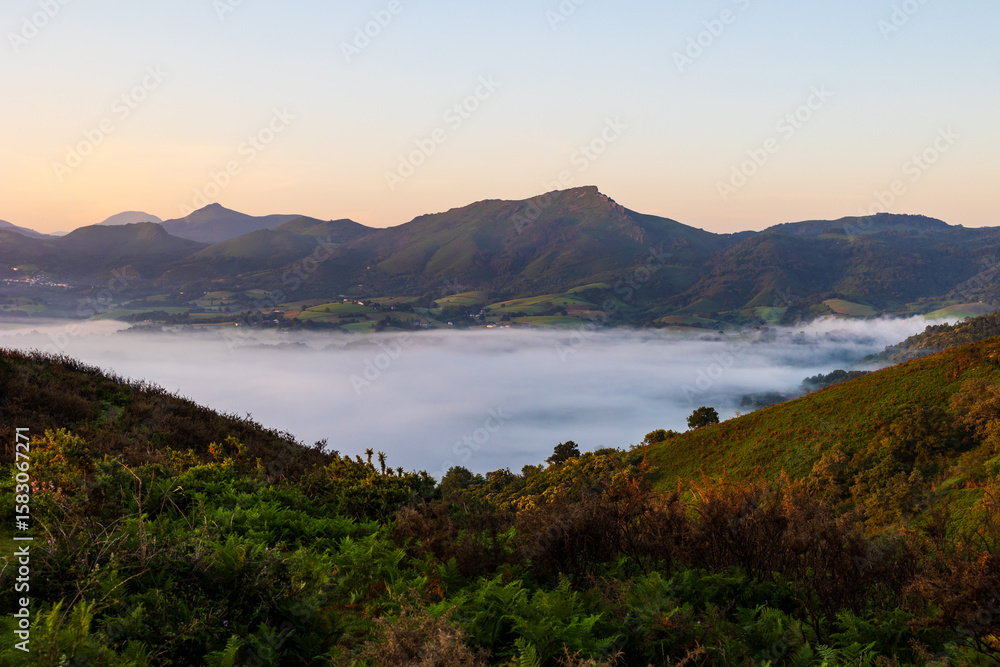 Fototapeta premium Mountains of the La Rhune Range Emerging from a Sea of Clouds at Sunrise in Sare