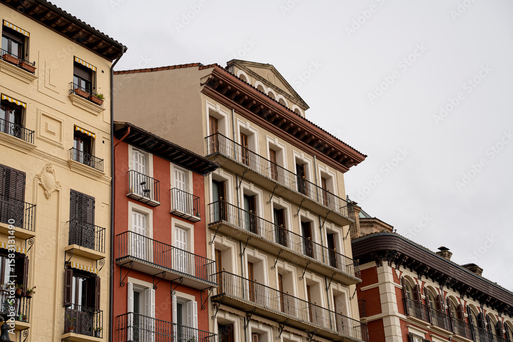 Fototapeta premium Historic architecture along a quiet street in Pamplona, Navarra, España showcases intricate designs and vibrant colors