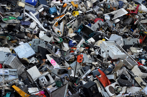 full-frame shot of disorganized pile of discarded electronic waste e-waste, a chaotic mix of computer components, wires, plastic casings, and circuit boards in various colors and states of disrepair.