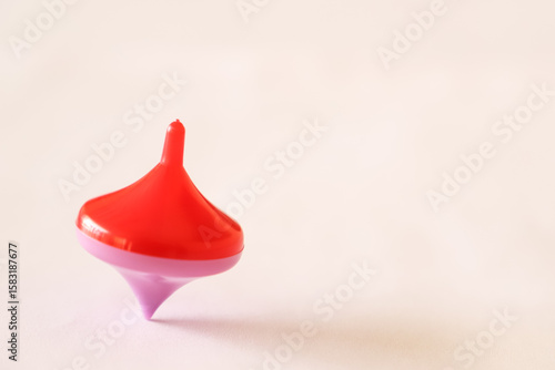 Foto pink and red spinning top spinning on a wooden table