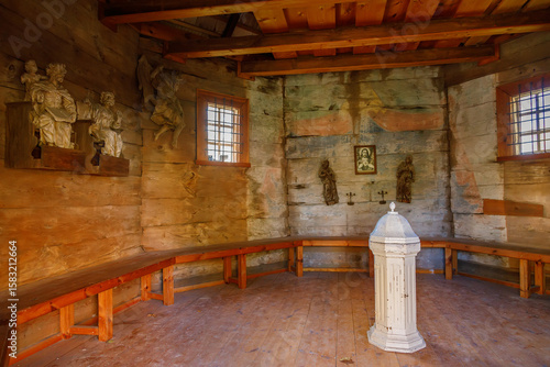 Принти на полотні Historic wooden church interior with stone walls carved religious sculptures woo