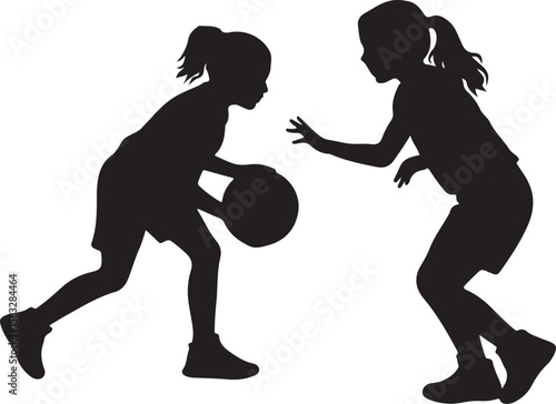 Two young girls playing basketball together in a dynamic silhouette