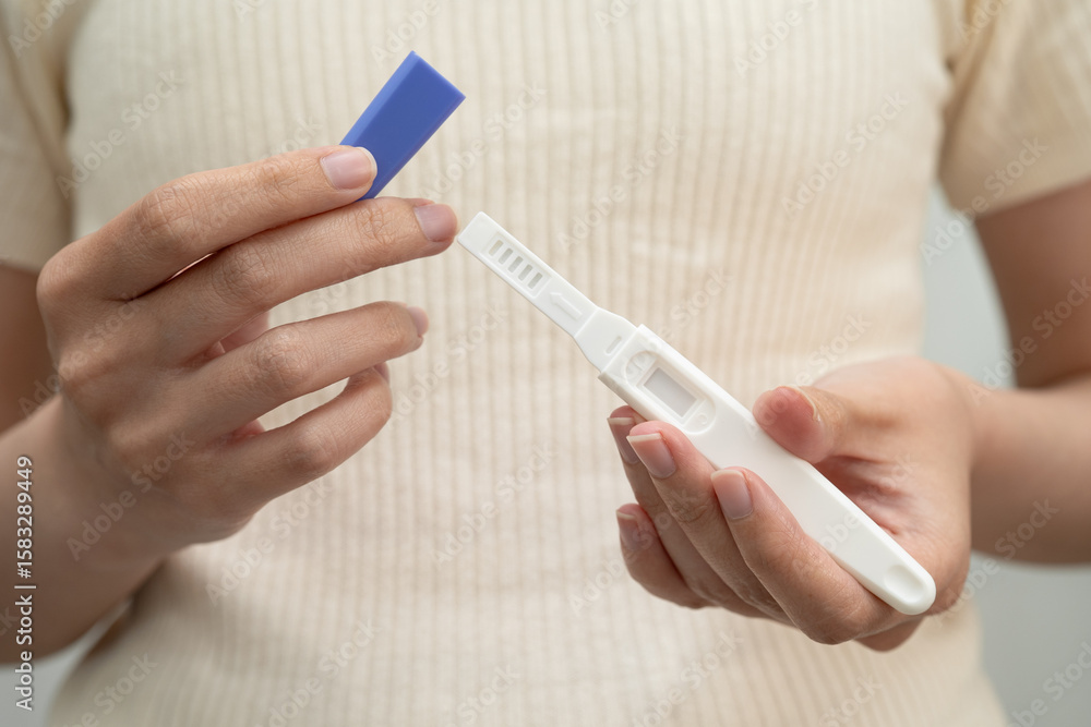 Asian holding pregnancy test for female of ovulation day, fetus, maternity, childbirth, birth control. Asian holding pregnancy test for female of ovulation day, fetus, maternity, childbirth, birth control.