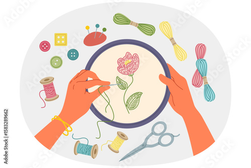 Hand embroidery and creative needlework using stretched canvas and needles with multi-colored threads. Woman embroiders wildflower while being keen on needlework and producing handmade goods