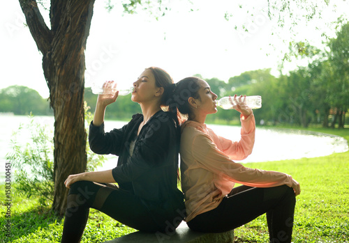 Obraz na płótnie Thirsty young woman and her friends are drinking water