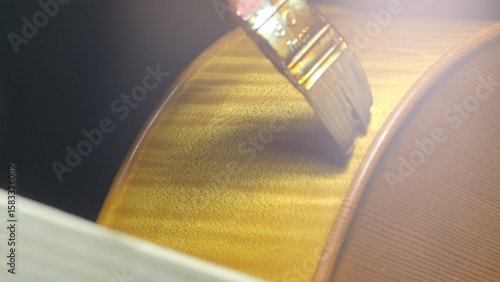 Fotografie Skilled luthier applying protective varnish to cello surface, showcasing precisi