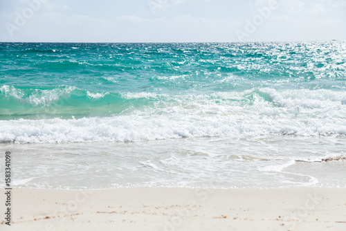 Waves wash up on white beach sand