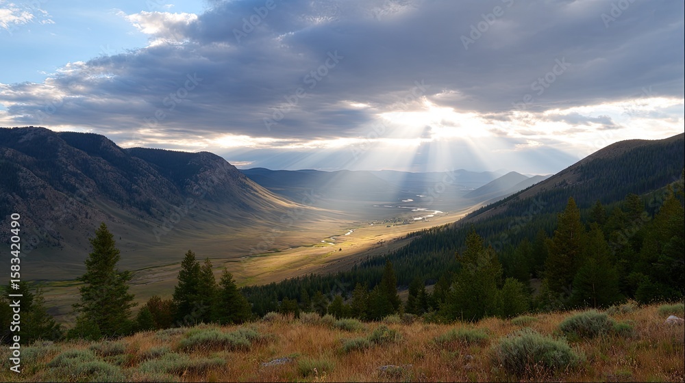Fototapeta premium Majestic Mountain Landscape with Sunlight Breaking Through Clouds Over a Serene Valley