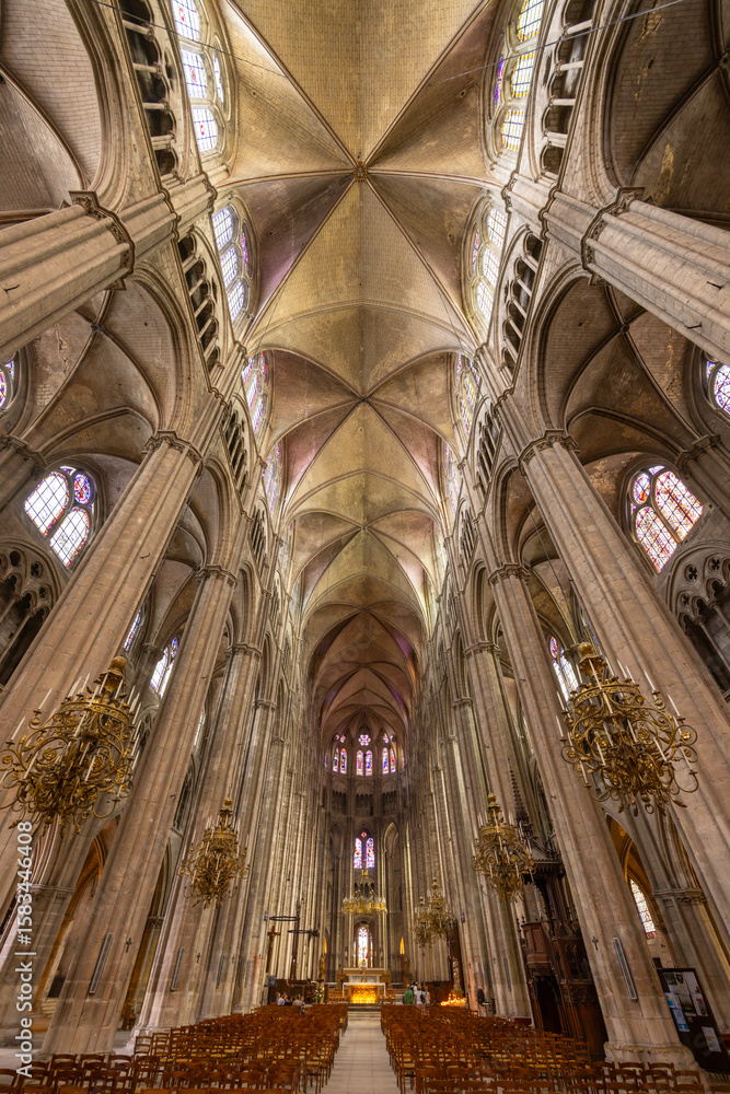 Obraz premium Bourges Cathedral nave showing gothic architecture, stained glass windows and chandeliers in France
