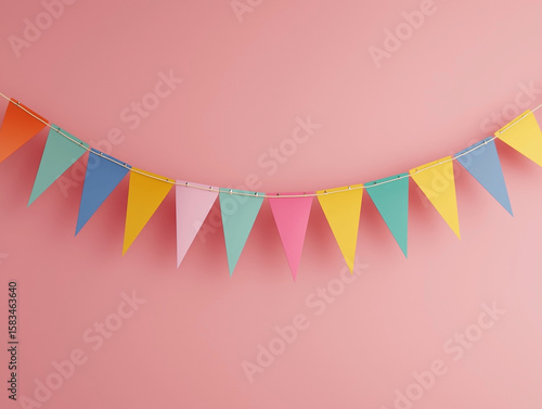 Colorful pennant bunting draped across soft pink wall