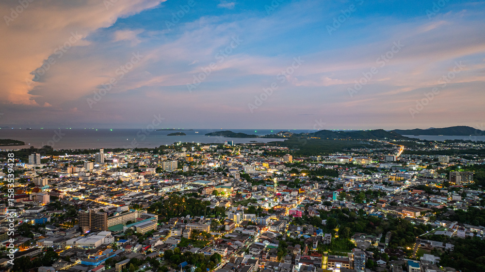 Fototapeta premium Aerial view of Khao Rang Viewpoint at dusk an important landmark in Phuket Town Khao Rang Viewpoint offers a panoramic view and the twinkling lights of Phuket Town at night, which are beautiful.