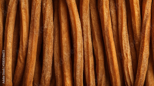 素朴なプレーンチュロスが縦に並ぶアップ構図。焼き菓子の質感や茶系背景素材として活用できるビジュアル。
