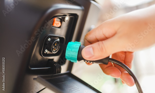 close up view of asian man hand taking off electric bicycle charger