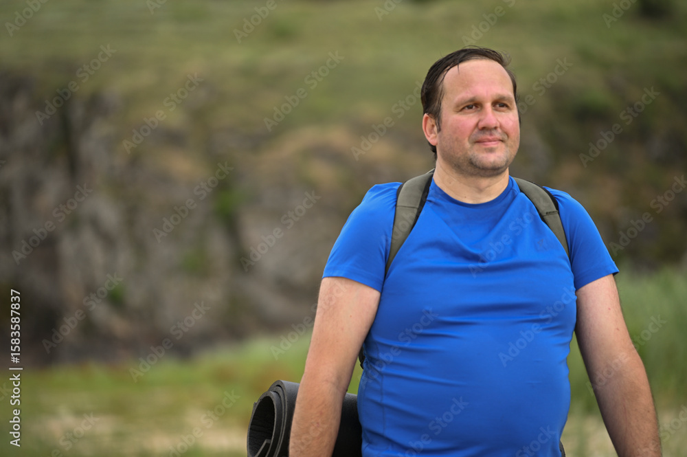Fototapeta premium a tourist with a backpack walks along the river beach