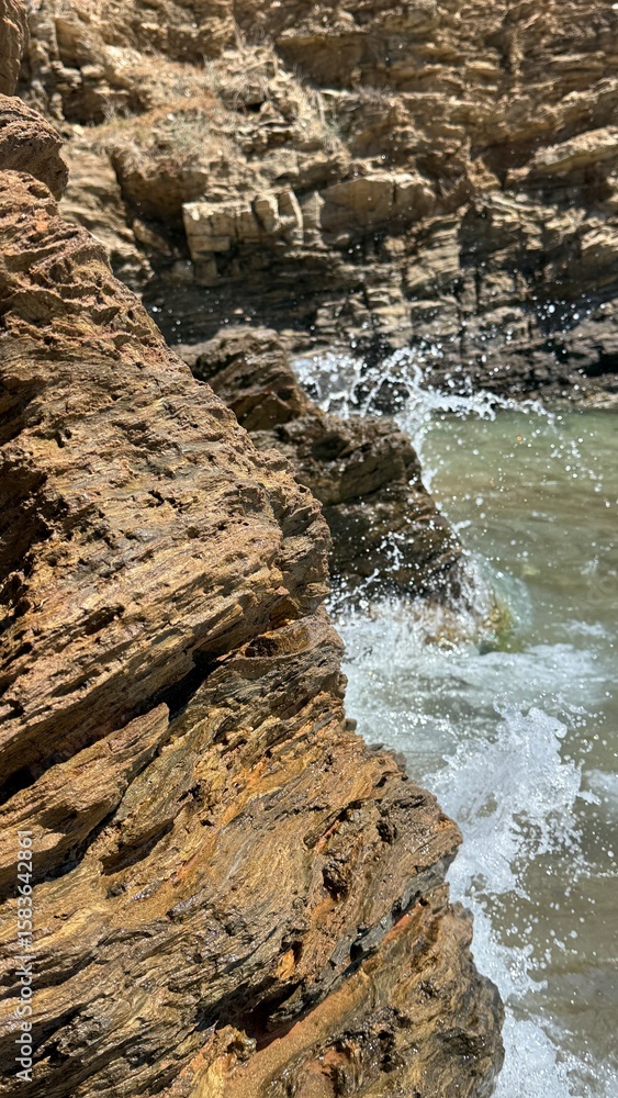 Fototapeta premium Rocky Coastline and Gentle Sea Waves – Tranquil Nature Background