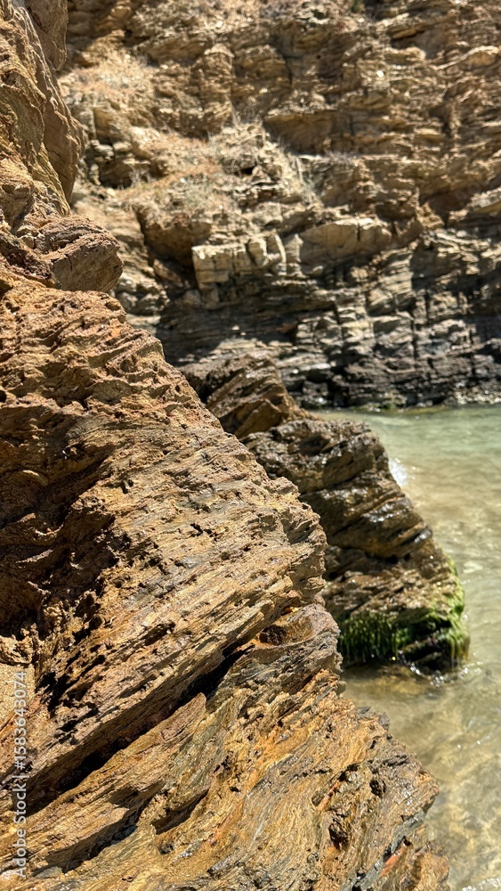 Fototapeta premium Rocky Coastline and Gentle Sea Waves – Tranquil Nature Background