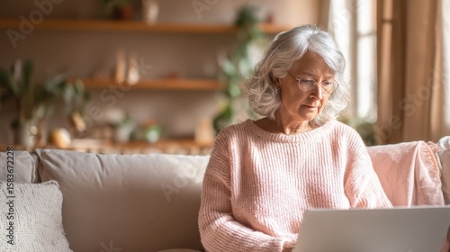 The elderly woman enjoying her time on a laptop in a cozy living room.