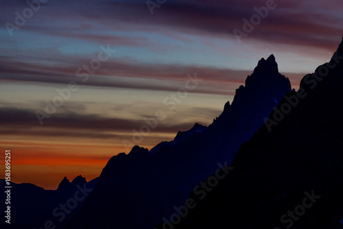 Beautiful mountain landscapes of the Alps on Tour du Montblanc hike. Green valley, snow summits and rocky peaks of Aiguilles de Chamonix and Montblanc. Summer sunny weather blue sky, trekking Alp hike