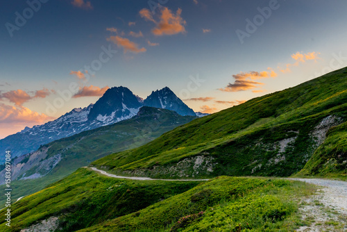 Beautiful mountain landscapes of the Alps on Tour du Montblanc hike. Green valley, snow summits and rocky peaks of Aiguilles de Chamonix and Montblanc. Summer sunny weather blue sky, trekking Alp hike