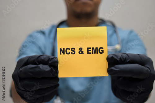 Fotografie Doctor holds in hands a card with the name of the Nerve conduction study NCS - Electromyography EMG