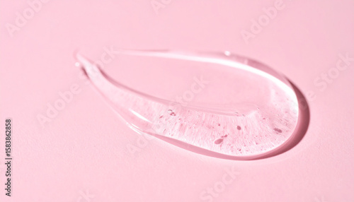 Transparent hyaluronic acid, gel or serum smear texture on pink backdrop. Moisturizing, skin care.