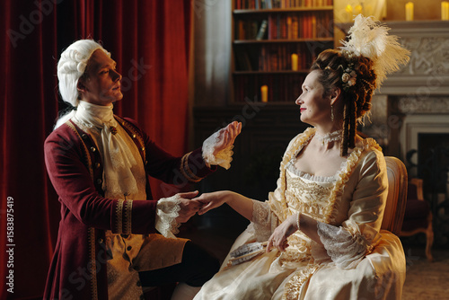 Obraz na plátně Caucasian middle aged man wearing Baroque period costume holding hand of Caucasi