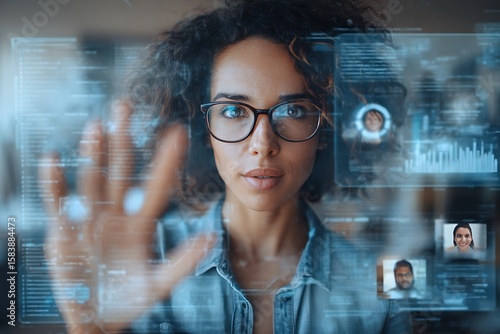 Focused woman interacting with a futuristic interface showcasing data analytics and team members, representing modern business