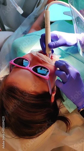 A child, a little girl, at a dentist's appointment,sitting in an armchair,close-up of a face,doing dental hygiene