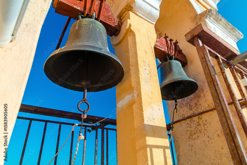 Obraz premium Bronze Bells Hanging Against Clear Blue Sky