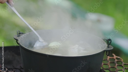 Cooking fish soup outdoors in summerIn a cauldron on a grill