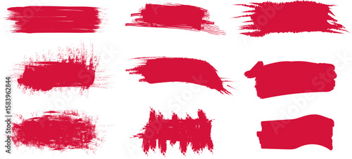 Vivid red brush strokes created with textured paint on a blank canvas showcasing artistic expression and creativity in a studio setting.